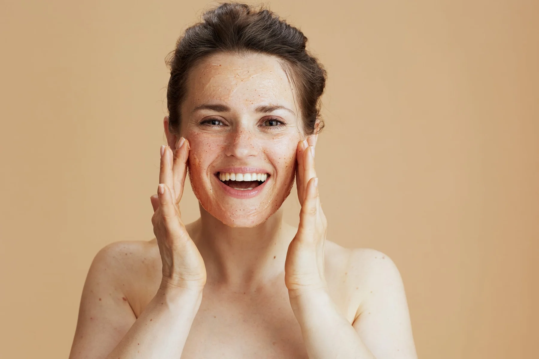 Smiling woman touching her face after a skin care treatment.